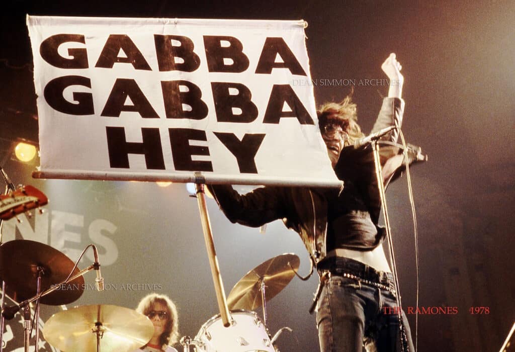 JOEY RAMONE HOLDS UP THE SIGN FROM "PINHEAD" ,THEIR SONG FROM 77', AT CHICAGO'S ARAGON BALLROOM, DRIVING THE CROWD INTO A FRENZY ON JANUARY 20TH, 1978.